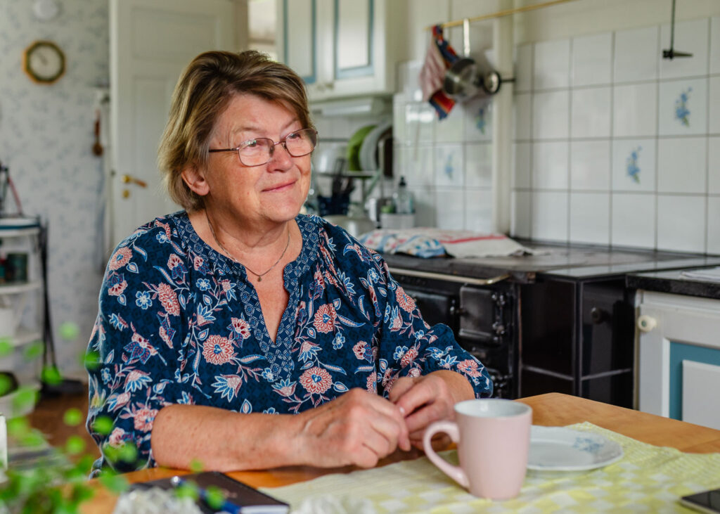 Aina dricker kaffe i köket i huset där hon växte upp.