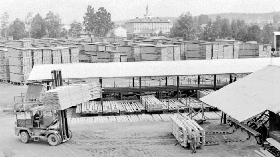En truck lastat med brädor kör över gårdsplanen på sågverket.